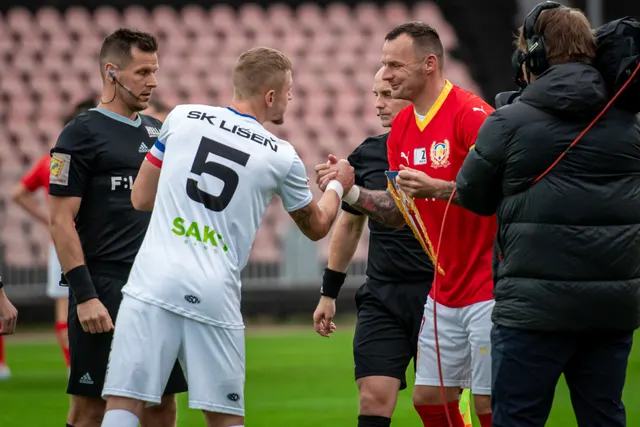 Kapitán SK Líšeň s číslem 5 si podává ruku s rozhodčím