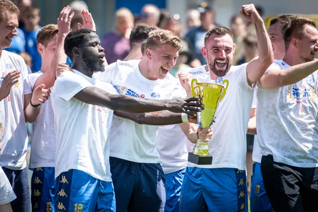 Fotbalisté slaví vítězství s pohárem